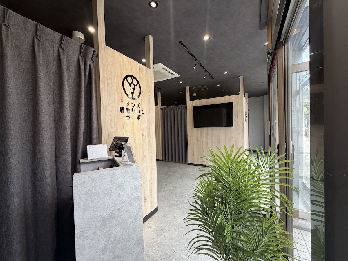メンズ眉毛サロンラボの店内。木目の壁にブランドロゴが入った、清潔感のある内装